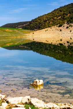 The beautiful crystal clear Aguelmame Sidi Ali Lake. Khenifra National Park, Middle Atlas Mountains, Morocco clipart