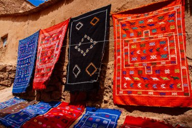 Kerpiç duvarında asılı renkli Berberi halıları. Ait Ben Haddou, Fas