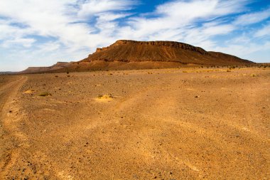 Dry stone desert and lonely table mountain in the background. Morocco clipart