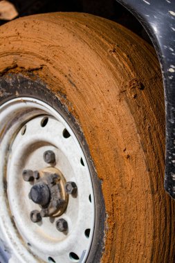 Background. Close-up. Dirty mud-covered wheel of an SUV. Adventure and travel concept clipart