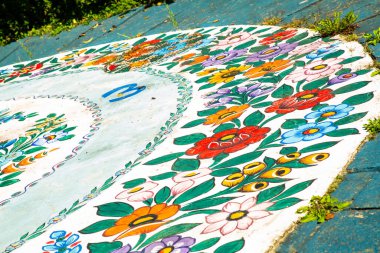 Zalipie, Polonya. 9 Eylül 2023: Polonya kültürü ve halk sanatı. Yakın plan. Geçmişi. Renkli süslü çiçeklerle boyanmış güneş saati parçası.