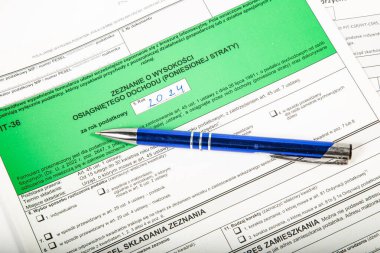 Close-up. Background. Green PIT-36. Polish tax return form for 2024 (called PIT) with pen.