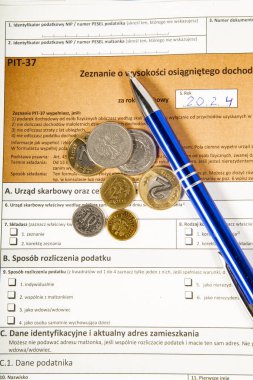 Yakın plan. Geçmişi. PIT-37. 2024 için Polonya vergi iade formu (PIT olarak adlandırılır) ve madeni para