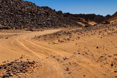 El Berdj Kanyonu 'nda kumlu toprak bir yol. Tassili n 'Ajjer Ulusal Parkı, Cezayir, Afrika  