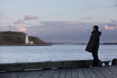 Halifax, Kanada - 19 Kasım 2022 körfezin kıyısında bir adam. Georges Adası 'ndaki deniz feneri, Halifax Limanı, Halifax Nova Scotia Kanada