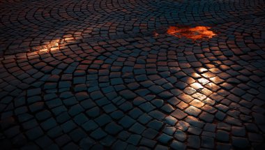 Eski kasabanın sokağındaki kaldırım taşı kaldırım yolu. Sabahleyin kaldırım taşı yolunda güneş ışığı. Eski taş dokusu