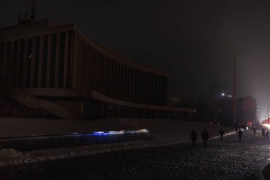 KYIV, UKRAINE - 16 Aralık 2022: Bilinç kaybı sırasında Ukrayna Konser Salonu. Yoldan geçenler geceleri karla kaplı kaldırımlarda görülebilir..