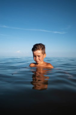 Çocuk ve deniz. Deniz kıyısında yaz tatili. Denizdeki küçük bir çocuğun portresi.