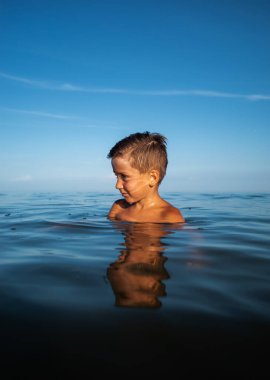 Çocuk ve deniz. Deniz kıyısında yaz tatili. Denizdeki küçük bir çocuğun portresi.