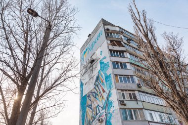KHERSON, UKRAINE - Mar. 08, 2023: Kherson 'da Rus ordusu tarafından Kherson' daki yerleşim alanlarının bombalanması sonucu hasar gören bir apartmanda görülen Vatansever duvar resmi.