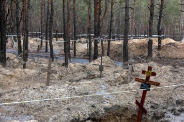 IZIUM, UKRAINE - Mar. 03, 2023: Ukrayna kuvvetleri tarafından geçtiğimiz günlerde Ukrayna 'nın Kharkiv bölgesinde kurtarılan Izium kasabasında mezardan çıkarılan bir orman mezarında haçlar görüldü..