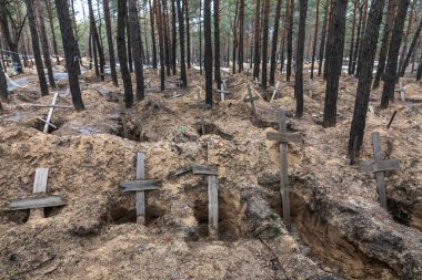 IZIUM, UKRAINE - Mar. 03, 2023: Ukrayna kuvvetleri tarafından geçtiğimiz günlerde Ukrayna 'nın Kharkiv bölgesinde kurtarılan Izium kasabasında mezardan çıkarılan bir orman mezarında haçlar görüldü..