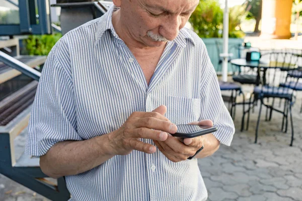 Elderly Man Holds Mobile Phone While Waiting His Morning Coffee — Stock Photo, Image