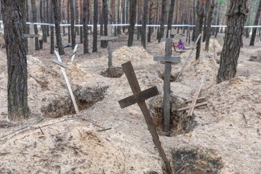 İzmir, Ukraine, efendim. 19, 2023: Ukrayna kuvvetleri tarafından geçtiğimiz günlerde Ukrayna 'nın Kharkiv bölgesinde kurtarılan Izium kasabasındaki mezardan çıkarılan bir orman mezarında haçlar görüldü..