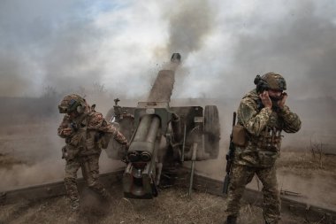 DONETSK REG, UKRAINE - Mar. 21, 2023: Ukrayna 'ya karşı Rusya Savaşı. Ukrayna silahlı kuvvetlerinden topçular 122 mm 'lik havan topu D-30' dan Bakhmut yakınlarındaki Rus mevzilerine ateş ediyorlar.