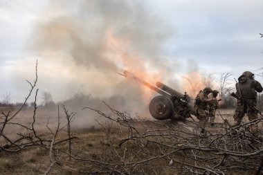 DONETSK REG, UKRAINE - Mar. 21, 2023: Ukrayna 'ya karşı Rusya Savaşı. Ukrayna silahlı kuvvetlerinden topçular 122 mm 'lik havan topu D-30' dan Bakhmut yakınlarındaki Rus mevzilerine ateş ediyorlar.