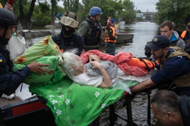 Kherson, Ukrayna, Haziran. 12, 2023: Cankurtaranlar ve gönüllüler, yaralı yaşlı insanları sedyelerle sel basmış bölgelerden tahliye ederken görüldü.