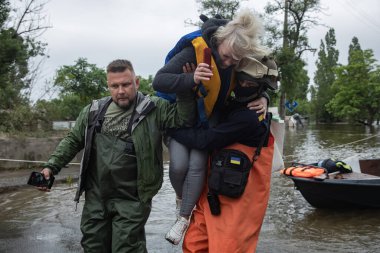 Kherson, Ukrayna, Haziran. 12, 2023: Kurtarma görevlileri ve gönüllülerin sel basmış bölgeden yerel halkı taşıdıkları görüldü.