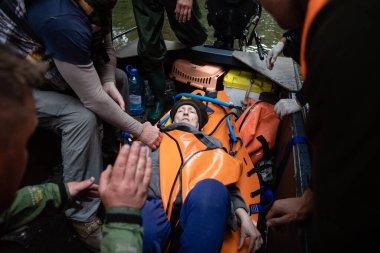 Kherson, Ukrayna, Haziran. 12, 2023: Cankurtaranlar yaşlı ve çaresiz bir kadını sel bölgesinden tekneyle çıkarırken görüldü..