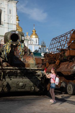 15 Temmuz 2023 'te Ukrayna' nın başkenti Kyiv 'de yıkılan Rus askeri araçlarının sergilendiği sergide kamuoyuna gösterilen yıkılan askeri araçların fotoğrafını çeken kız..
