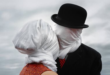 Faceless portrait of man kissing woman with white fabrics on their heads clipart