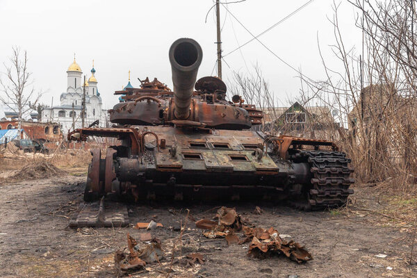 War in Ukraine. A burnt-out Russian tank is seen on the street of Svyatogirsk, Donetsk region, Ukraine against the background of churches