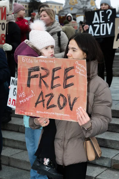 KYIV, UKRAINE - 18 Şubat 2024: Çocuklu genç bir annenin elinde özgür bir AZOV posteri olduğu görülüyor.