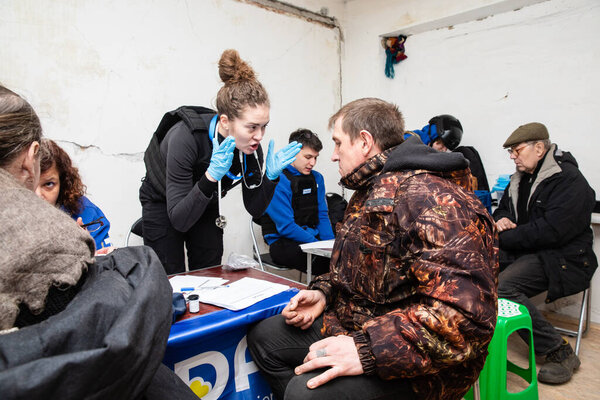CHASIV YAR, DONETSK REG., UKRAINE - Mar. 09, 2024: A volunteer doctor from Frida Mission Ukraine giving advice to a man seeking medical assistance