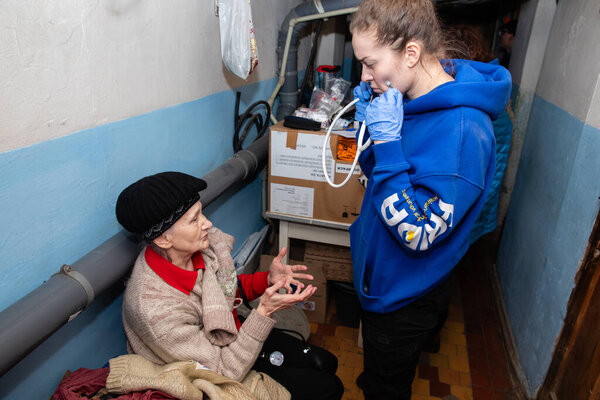 SIVERSK, DONETSK REG., UKRAINE - Mar. 10, 2024: An elderly woman is seen talking about her health problems to a doctor from the Frida Ukraine Volunteer Mission.