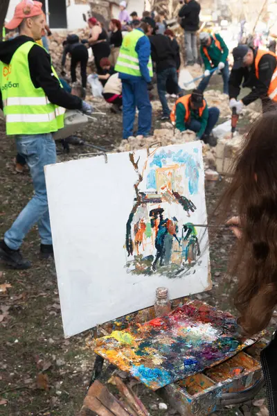 stock image KYIV, UKRAINE - Mar. 30, 2024: Students of the art academy are making artistic sketches during the removal of the rubble of the destroyed academy building.