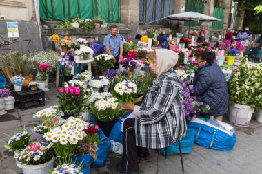 IV, UKRAINE - Mayıs. 19, 2024: Kadınlar Lviv 'in tarihi merkezinde pazar meydanında çiçek satarken görülüyor.