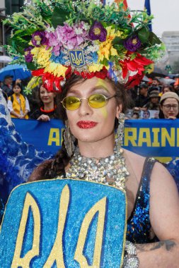 KYIV, UKRAINE - Haziran. 16, 2024: Kyiv 'deki eşitlik yürüyüşü sırasında başında çiçek çelengi ve Ukrayna arması olan bir LGBT aktivisti görülüyor