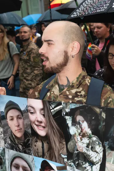 stock image KYIV, UKRAINE - Jun. 16, 2024: LGBT activist carrying portraits of gay and lesbian military personnel on a placard reading We are their voices. Military LGBT.