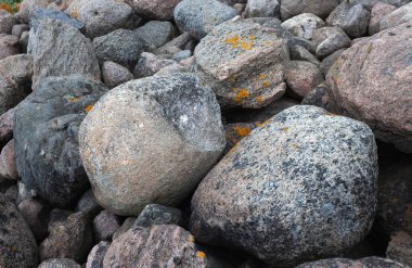 Büyük kayalar eski bir taş iskelenin sahasına rastgele dağılmış. Taşlar arka plan ve doku. Ainazi Kuzey İskelesi