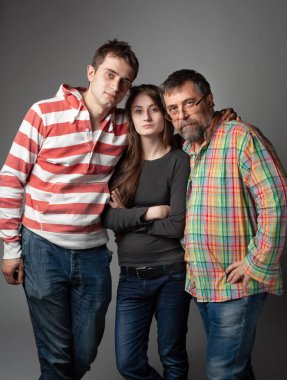 Stüdyoda baba, oğul ve kızın aile portresi.