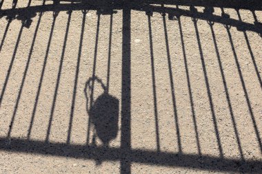 Işık ve gölge. Asfalttaki korkulukların gölgesi. Soyut arkaplan ve doku.