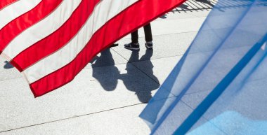 Washington DC, USA - Oct. 10, 2022: Silhouettes of people united under the American flag. Patriotic demonstration near the White House fence clipart