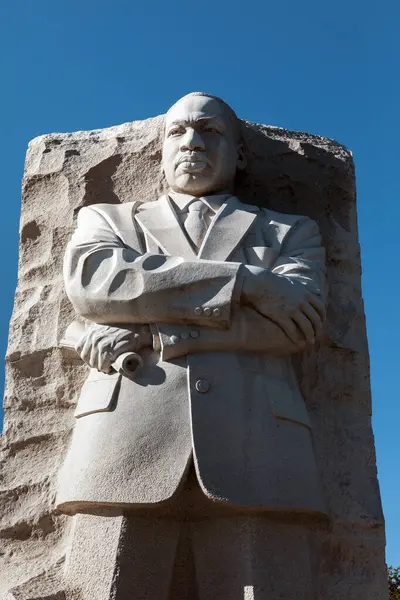 Washington DC, ABD - 10 Ekim 2022: Martin Luther King Jr., Dr. King 'in kolları çaprazlanmış büyük taş bir heykeli, bir parşömen tutuyordu. Anıt açık mavi bir gökyüzüne karşı duruyor.