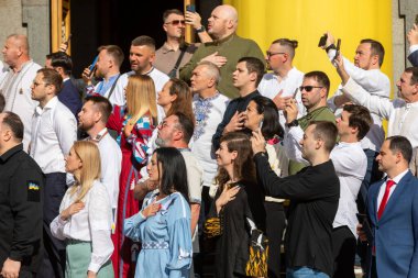 KYIV, UKRAINE - Aug. 23, 2024: A solemn ceremony near the Verkhovna Rada on State Flag Day. A group of people's deputies during the flag-raising ceremony and singing of the national anthem clipart