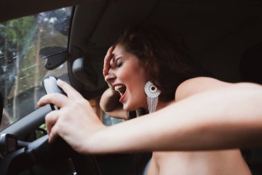 Kırsalda araba sürmeyi öğrenirken direksiyon başında çıplak bir kadın.