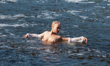 Güneşli bir yaz gününde doğada çıplak poz veren genç ve güzel bir kadın. Güzellik, gençlik ve çıplaklık.