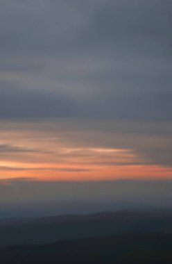 Gün geceye geçerken ufuk boyunca yumuşak renkler dağılır. Yumuşak bulutlar, sakin bir ortamda, derin düşüncelere daldıran barışçıl, yansıtıcı bir ruh hali uyandırır..