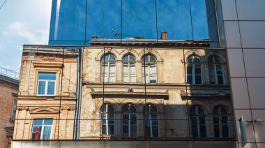 Lviv, Ukrayna - Mar. 22, 2025: Eski bir mimari harikanın çarpıcı bir birleşimi ve gösterişli bir modern görünüş. Lviv 'de, tarih her yansımada yankılanır, şehrin özünü yakalar..