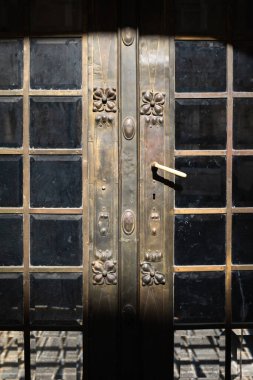 Lviv, Ukrayna - Mar. 22, 2025: Ukrayna 'nın başkenti Lviv' de öğleden sonra güneşiyle aydınlanan güzel el yapımı metal kapılar çiçek desenleri sergiliyor..
