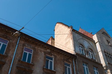 Lviv, Ukrayna - Mar. 22, 2025: Ilık güneş ışığı, bu canlı şehrin zengin mimari tarihini ve kentsel atmosferini gözler önüne seren Lviv 'in büyüleyici eski binalarına gölge düşürüyor..