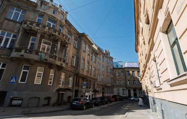 Lviv, Ukrayna - Mar. 22, 2025: Lviv 'de güneşli bir günde muhteşem mimari sergilenen tarihi binalarla dolu güzel bir cadde ortaya çıktı. Titreşimli atmosfer keşfi davet ediyor..