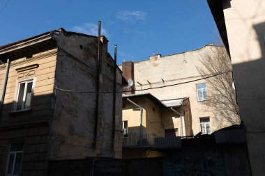 Lviv, Ukrayna - Mar. 22, 2025: Lviv, Ukrayna 'nın büyüleyici caddelerinin ortasında, eski yapılar karmaşık mimarilerini sergiliyor, güneş ışığı gölgeleri gibi, şehirlerin zengin tarihini gözler önüne seriyor..
