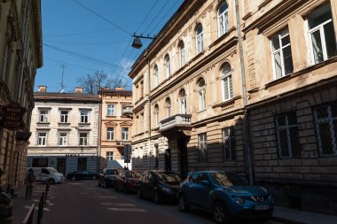 Lviv, Ukrayna - Mar. 22, 2025: Canlı Lviv şehrinde, güneş ışığı altındaki caddeler büyüleyici mimari ve büyüleyici binalar sergiliyor, ziyaretçileri tarih ve kültürde unutulmaz bir gezintiye davet ediyor..