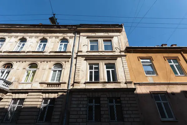 Lviv, Ukrayna - Mar. 22, 2025: Lviv, Ukrayna 'da güzel klasik binalar, parlak mavi bir gökyüzünün altında, şehrin zengin kültürel mirasını ve mimari harikalarını yansıtıyor..