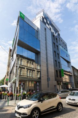 LVIV, UKRAINE - Haziran. 20, 2021: Çağdaş konukseverlikle tarihi mimari arasındaki çarpıcı tezat Lviv şehir merkezinin cazibesini gözler önüne seriyor. Ziyaretçiler kaldırım taşlı caddelerde geziniyor.